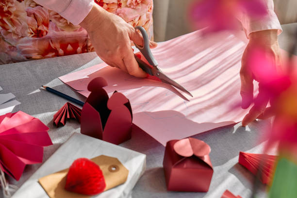 istock Paper craft diy. Woman's hands making handmade heart shaped gift box for Valentines day, birthday, Mothers day, wedding. 1951985182