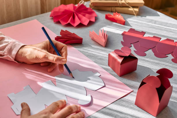istock Paper craft diy. Woman's hands making handmade heart shaped gift box for Valentines day, birthday, Mothers day, wedding. 1951985185