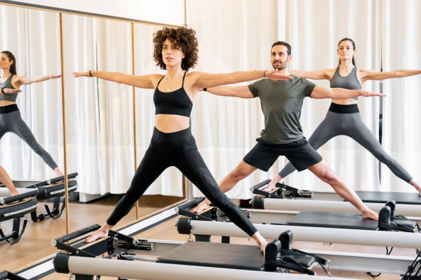 istock People doing pilates standing pose on reformer beds in gym 1952016097