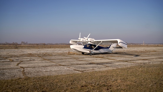 The plane is private for skydiving. White private jet. White propeller plane. Private small plane in the field.