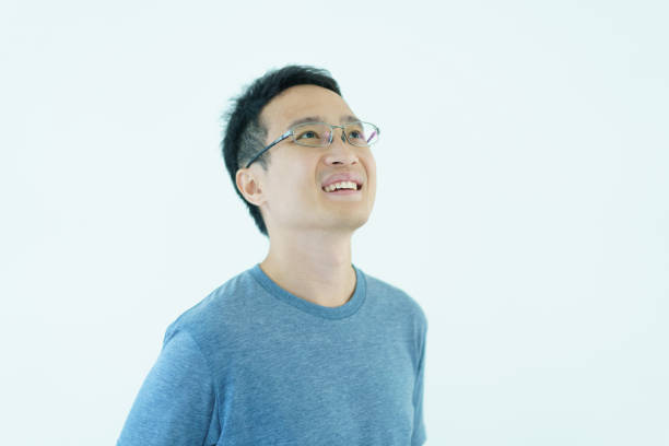 Happy Asian good looking - handsome man portrait, age between 30 - 35 years old. Close up on upper body of a good looking Asian middle adult male laughing and smile to camera. Delightful man portrait close up.