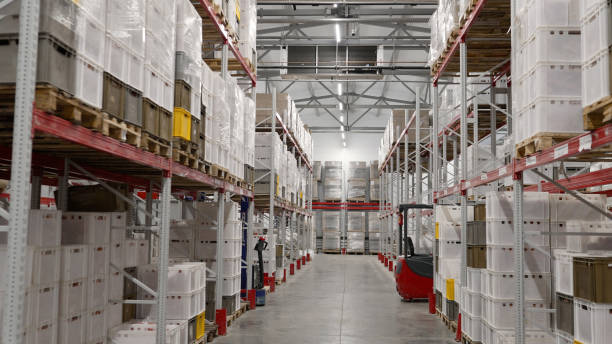 istock Warehouse interior. Large industrial warehouse. Tall metal shelves filled with various boxes and containers. Light warehouse with shelving. 1952037319