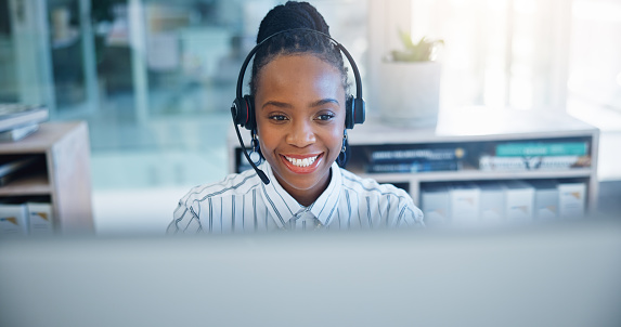 Black woman, call center and consulting on headphones in customer support, service or telemarketing at office. African female person, consultant or agent talking in online advice or help at workplace