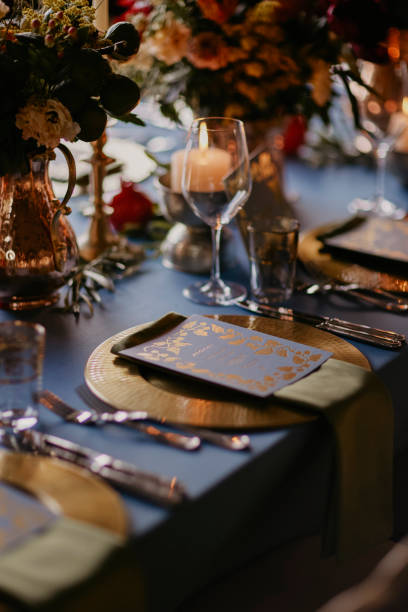bohemian style wedding dining table decorated with a blue covered bronze vase and pomegranate figures. stock photo