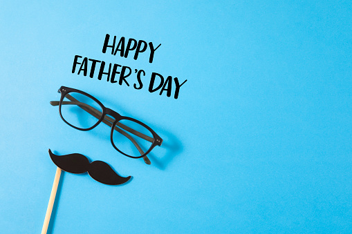 Happy Father’s day concept with mustache and eye glasses on blue background