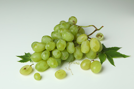 Green ripe grape with leaves on white background