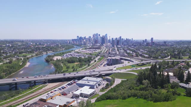 Flying over Shaganappi golf course with the bow river and the vista downtown of Calgary Alberta Canada coming more into view.