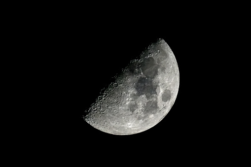 Partly illuminated moon in the dark night sky over Western Europe on January 18, 2024. The surface of the moon is clearly visible with various craters and seas.