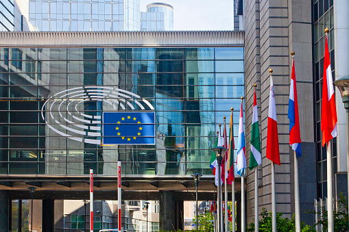 European Union Flag EU Flags side by side in the Wind- European Union in a row in front of the facade of the European Commission Headquarter blowing in the wind. Hasselblad 102 MPixel X2D 16:9 Crop.  Brussels, Belgium, Europe