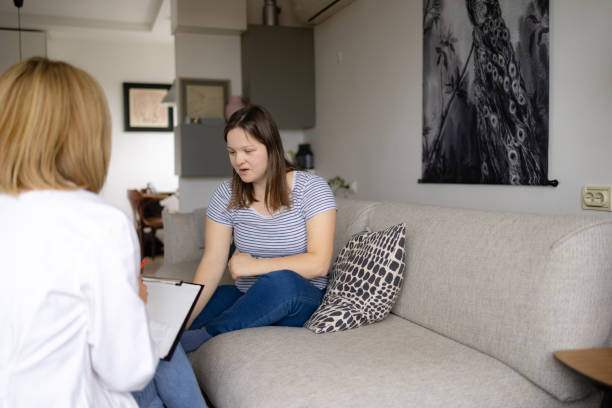 istock Sad woman with special needs having a home visit by her doctor. 1952145992