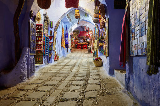 Narrow street with shops at night in the city of Chefchaouen, Morocco, Africa.