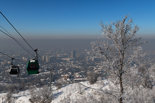 Almaty, Kazakhstan, 01.22.2024. A cable car over the Kazakh city of Almaty and winter smog, which is considered a real environmental disaster