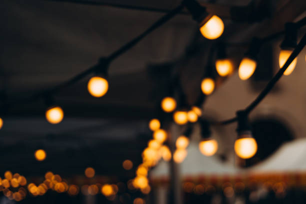 istock Blurred background of outdoor restaurant with abstract bokeh light. Abstract Blurred image of Night Festival on street with light bokeh 1952157852