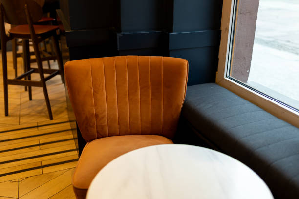 Modern restaurant interior background. An empty table and chair in a restaurant. A soft orange armchair