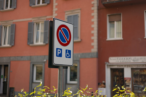 Sign indicating no parking in a space reserved for cars with disabled people.