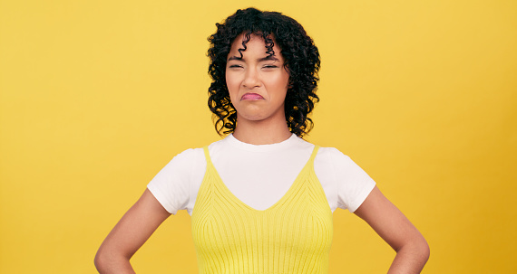 Gross, disgust and portrait of woman with reaction to news, announcement or information in studio. Frustrated, face and person in yellow background and mockup space with yuck emoji for dislike