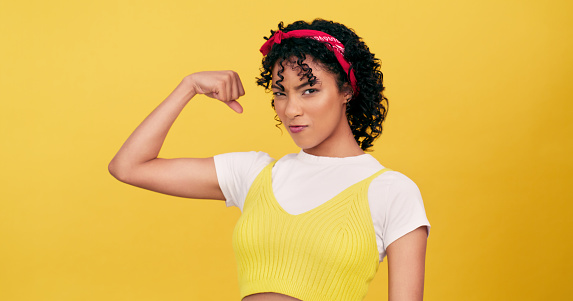 Portrait, strong and woman flex muscle in studio isolated on a yellow background mockup space. Fitness, girl and bicep arm for power, empowerment of confident young model and energy for feminism