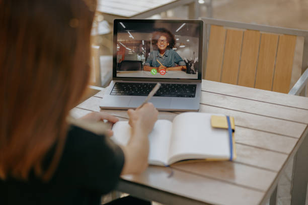 istock Female manager is talking with client via video call and making notes while sitting in cafe terrace 1952158713