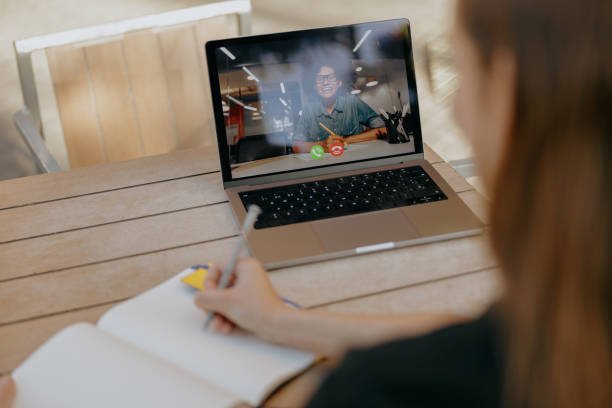 istock Female student talking with friend via video call and making notes while sitting in cafe terrace 1952159234