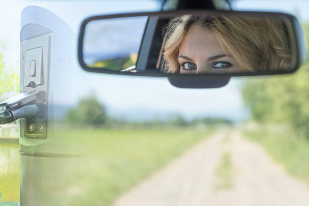 Stress from not reaching the destination by car is officially described by experts in drivers of electric cars. The beautiful eyes of the young driver woman are reflected