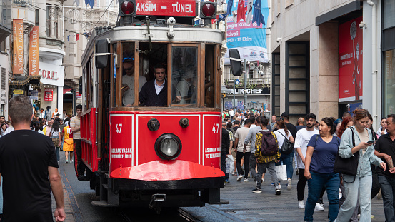 Istanbul-Turkey: Sep.20, 2023: Tourists and local people travelling by historical red tramway. Nostalgic tram in Taksim Istiklal Street. Taksim one of the most popular tourist destinations in Istanbul