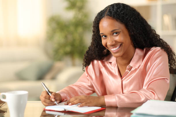 istock Black freelancer writing in agenda looks at you 1952179769