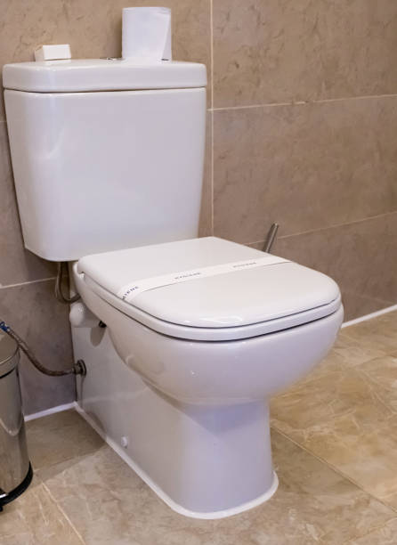 istock Ceramic toilet bowl near brown marble wall 1952192609