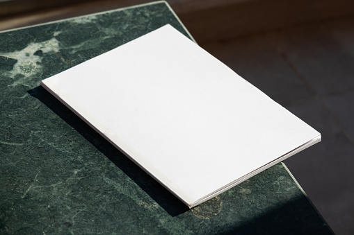 Magazine cover mockup design. blank magazine mockup on green marble stone coffee table , shadow overlay