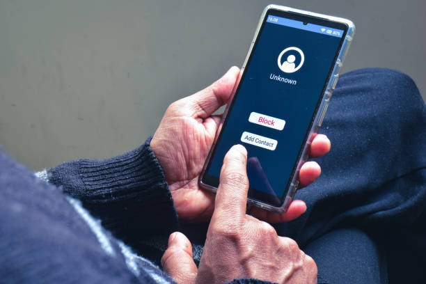 istock Man decision making moment on blocking unknown caller phone number to prevent voice phishing scam call. Selective focus. 1952248187