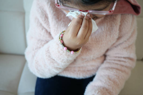 istock Sick child with flu blow nose with napkin. 1952255031