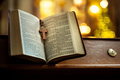 Open Bible on a wood table with light coming from above. ( church concept ).