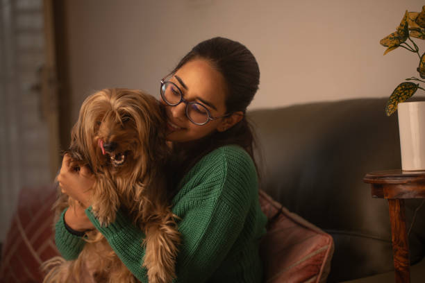 istock Smiling woman embracing dog on sofa 1952272462
