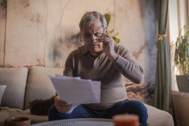 istock Worried senior man holding papers in his hand 1952281419