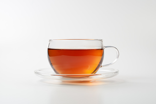 Hot tea in an antique cup and saucer on a white background with copy space