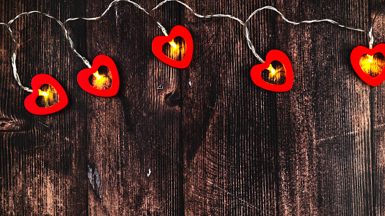 Garland with hearts on wooden background with space for text. Valentine's Day celebration