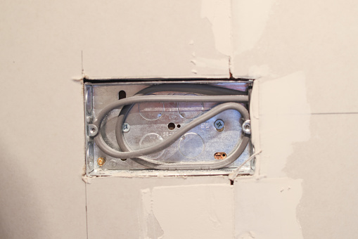 Electrician 'First fix' of a UK power outlet in a kitchen renovation project