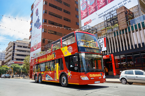 Joburg Citysightseeing tour bus travelling through Braamfontein in Johannesburg. Johannesburg is also known as Jozi, Jo'burg or eGoli, is the largest city in South Africa.