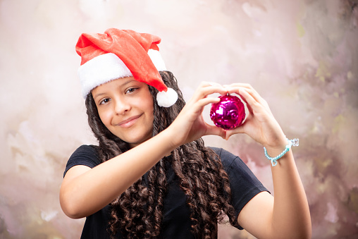 Teenage Brazilian woman with Christmas ornaments, abstract background, selective focus.