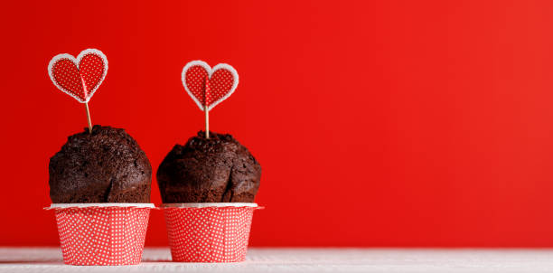 istock Cupcake love: Heart-themed treats on a vibrant red backdrop 1952396148