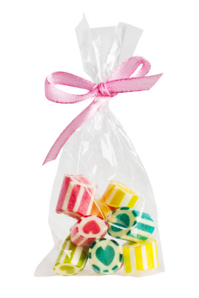 istock Small colored candies in a white transparent bag with a bow. On a blank background 1952408535