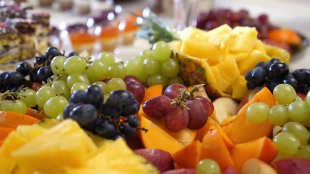 Fruit buffet. Grapes, pineapples, oranges, apples and others. Slow motion.