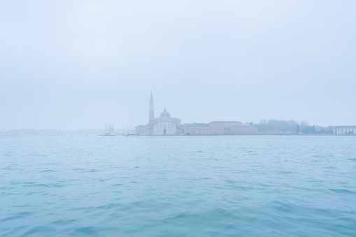 A misty pre-dawn in Venice, Italy, and the magnificent form of the Church of San Giorgio Maggiore can be seen across the waters of the Grand Canal.