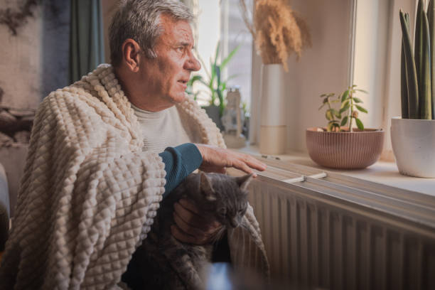 istock Energy crisis, man feels the cold next to the radiator 1952418906