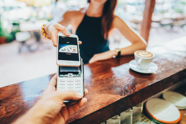 istock Woman at beach bar paying contactless with smartphone for coffee 1952425140