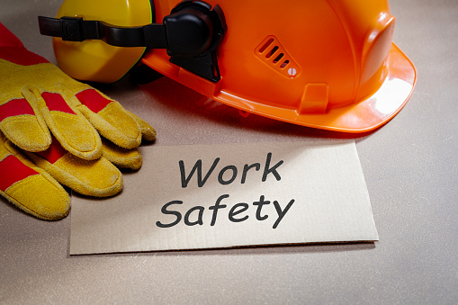 work safety word written on paper list and work safety protection equipment on the desk.