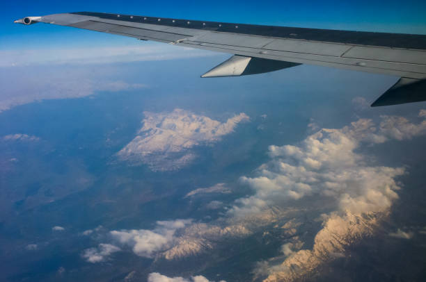 istock Clouds and mountains below, view from an airplane window 1952446888