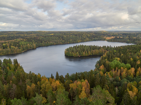 Horizontal panorama from top of Aulanko lookout tower near the Finnish town Hamenlinna: autumn forests, lake, clouds.