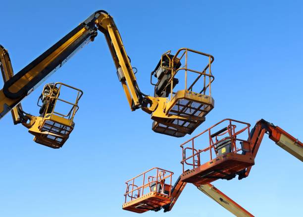 istock Two aerial working platforms of cherry pickers in front of other two. 1952506679