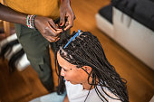 Black Female Hairstylist Working on Mixed Race Female Client at Home