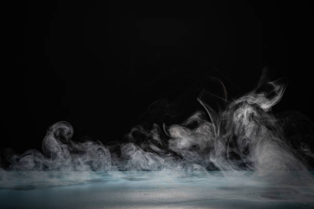 клубящийся белый дым на темном фоне в студии при слабом освещении - lowlight стоковые фото и изображ�ения